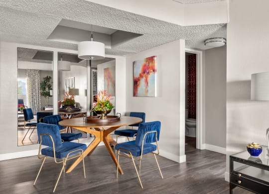 a dining area with a wooden table and blue chairs